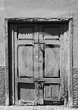 Old broken bolted shut door in an abandoned house
