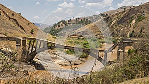 Old broken bridge on a muddy river