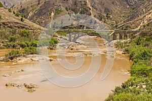 Old broken bridge on a muddy river