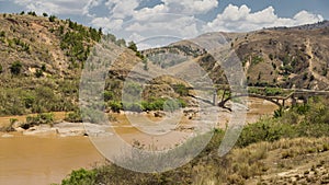 Old broken bridge on a muddy river