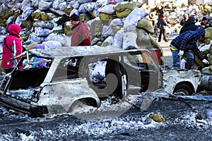 Old broken car stuck in ice on a background of the barricades