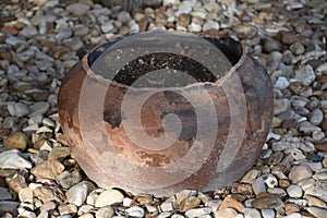 Old broken clay pot set in a bed of rock