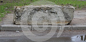 An old broken concrete block blocks the entrance to the sidewalk