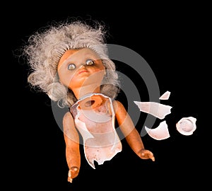 Old broken cracked doll torso isolated on a black background