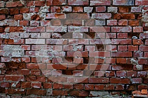 Old broken, damaged and corroded brick wall with broken bricks missing and leaving holes in the wall for background or wallpaper