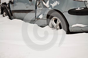 An old broken-down car in the snow