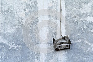 old broken electric socket on dirty cement wall