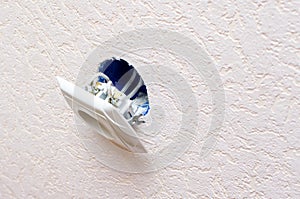 Old broken electrical socket fell out of wall