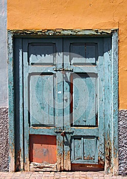 Old broken green bolted shut door in an abandoned house