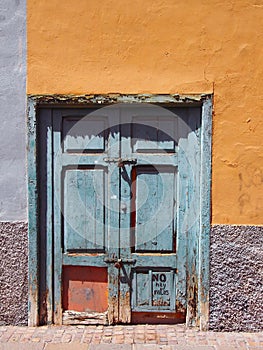 Old broken green closed wooden door bolted shut
