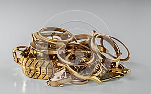 Old and broken jewelry, watches of gold and gold-plated on a grey background