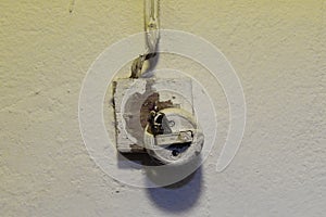 Old broken light switch with exposed wires.