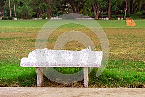 Old and broken long white cement bench for relaxing after the exercise beside the exercise yard
