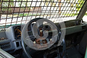 old broken military vehicle with bars on the front window, the car after the passage of hostilities