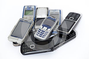 Old and broken mobile phones on a white background 