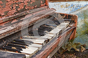 An old broken piano in the street with a large pan with white and black keys