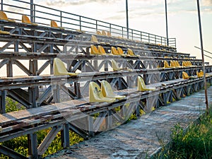 Old broken plastic chairs at the stadium. Abandoned stand at the stadium. Concept of devastation