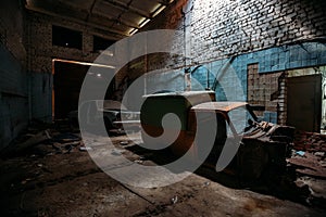 Old broken rusty cars inside abandoned repair garage