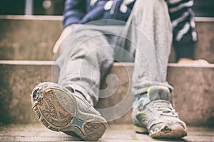 Old broken shoes of a little boy as a symbol for child poverty photo