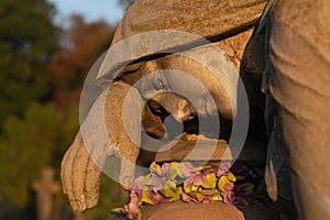 Old, broken statue of sad woman in grief. Virgin Mary stone sculpture. Sunset suffering, death concept