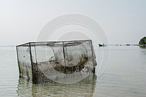 Old broken trap for lobsters at the tropical beach