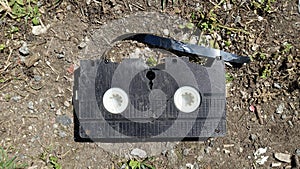An old broken video cassette abandoned on the ground.