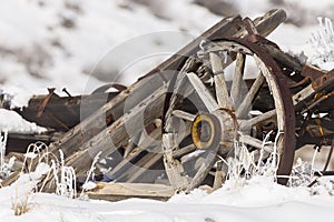 Old broken wagon with wheel in snow