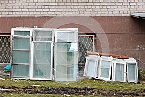 Old broken white wooden windows are withdrawn from the building for replacement by new plastic windows