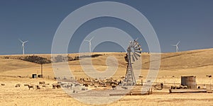 Old broken wind pump and new wind generators. Australia.