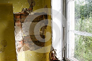 Old broken window and bricks wall in the abandoned house