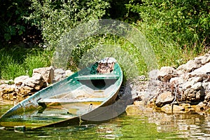 Old broken wooden boat under the water on the river coast