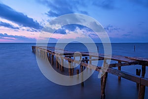 Old broken wooden bridge in the sea, long exposure, sunrise