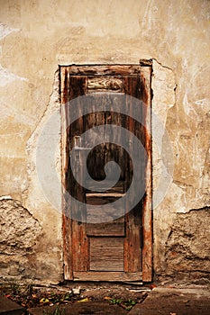 Old broken wooden brown door with handle high over ground