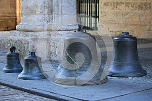Old bronze bells on the pavement. The Captain Generals Palace photo