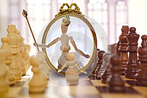 old, bronze crown on anthropomorphic white queen in oval mirror, pawn, duel queen figures on chessboard blackboard