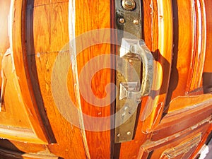 Old bronze door handle close-up on a wooden red door