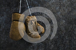 Old brown Boxing gloves hanging on the wall