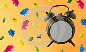 Old brown clock with blank space and colorful flowers flying on a orange background. Positive news, thinking and energy concept.