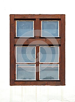 Old brown closed wooden window home with glass on a background with a white facade. Plastic window frame house with natural wood i