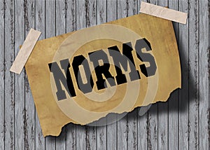 Old brown paper with NORMS text on wooden background.