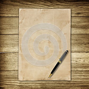 Old brown paper and pen on wooden wall background for texture