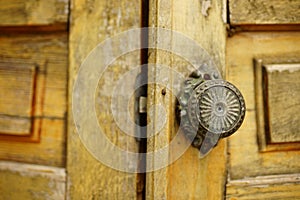 Old brown shabby wooden door with an iron round handle