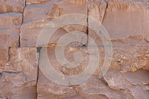 Old brown stone wall background, rough block texture.