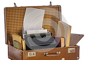 Old brown suitcases with old retro typing machine on white background