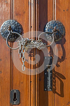 Old brown wooden door handles,chain and lock