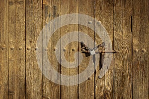 Old brown wooden door with a rusty bolt