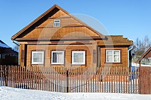 Old brown wooden house in winter time