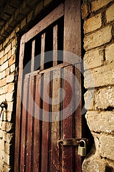 Old brown wooden door in white brick wall