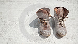 Old brown work boots covered in concrete