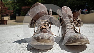 Old brown work boots covered in concrete